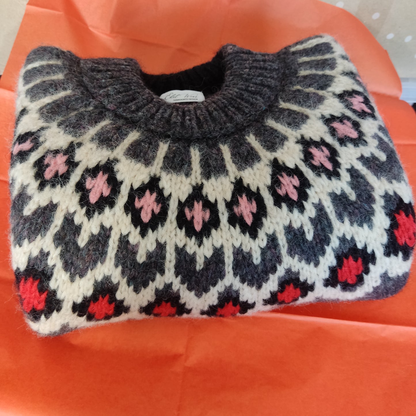 Hand-knitted dark marengo oversized unisex chunky knit Scandinavian sweater Lopapeysa Fair Isle with a cream, red and pink Nordic round yoke, featuring a double collar, ribbed hem, and cuffs in marengo, made from soft hypoallergenic baby alpaca and extrafine merino wool.