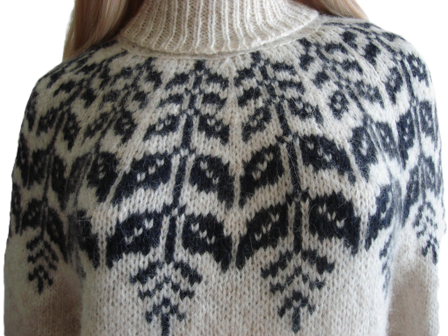 Close-up of a sweater with a black and white pattern on a neutral background
