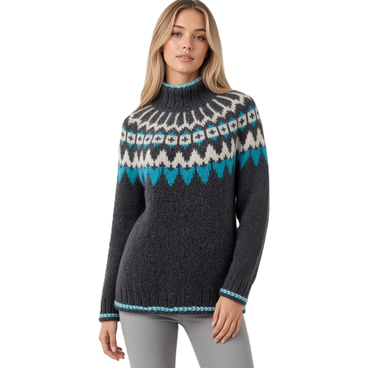 A woman modeling a dark gray knit sweater with a white and turquoise Fair Isle pattern across the chest and shoulders, paired with gray pants, against a plain white background.