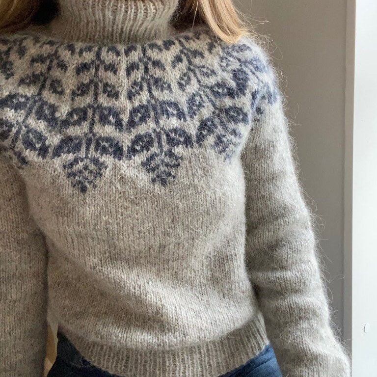 Close-up of a person wearing a sweater with a patterned neckline.