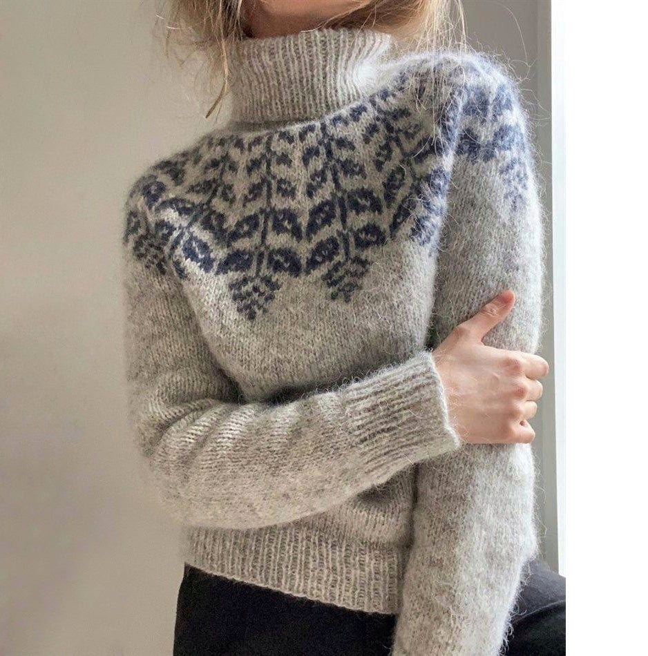 Gray sweater with blue leopard print pattern worn by a person