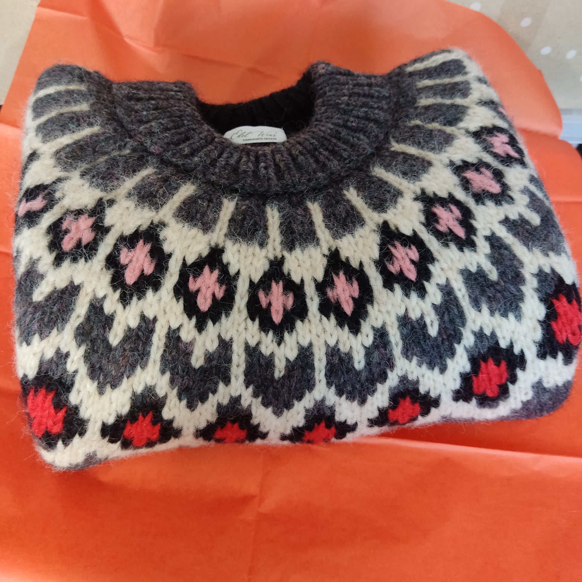 Hand-knitted dark marengo oversized unisex chunky knit Scandinavian sweater Lopapeysa Fair Isle with a cream, red and pink Nordic round yoke, featuring a double collar, ribbed hem, and cuffs in marengo, made from soft hypoallergenic baby alpaca and extrafine merino wool.