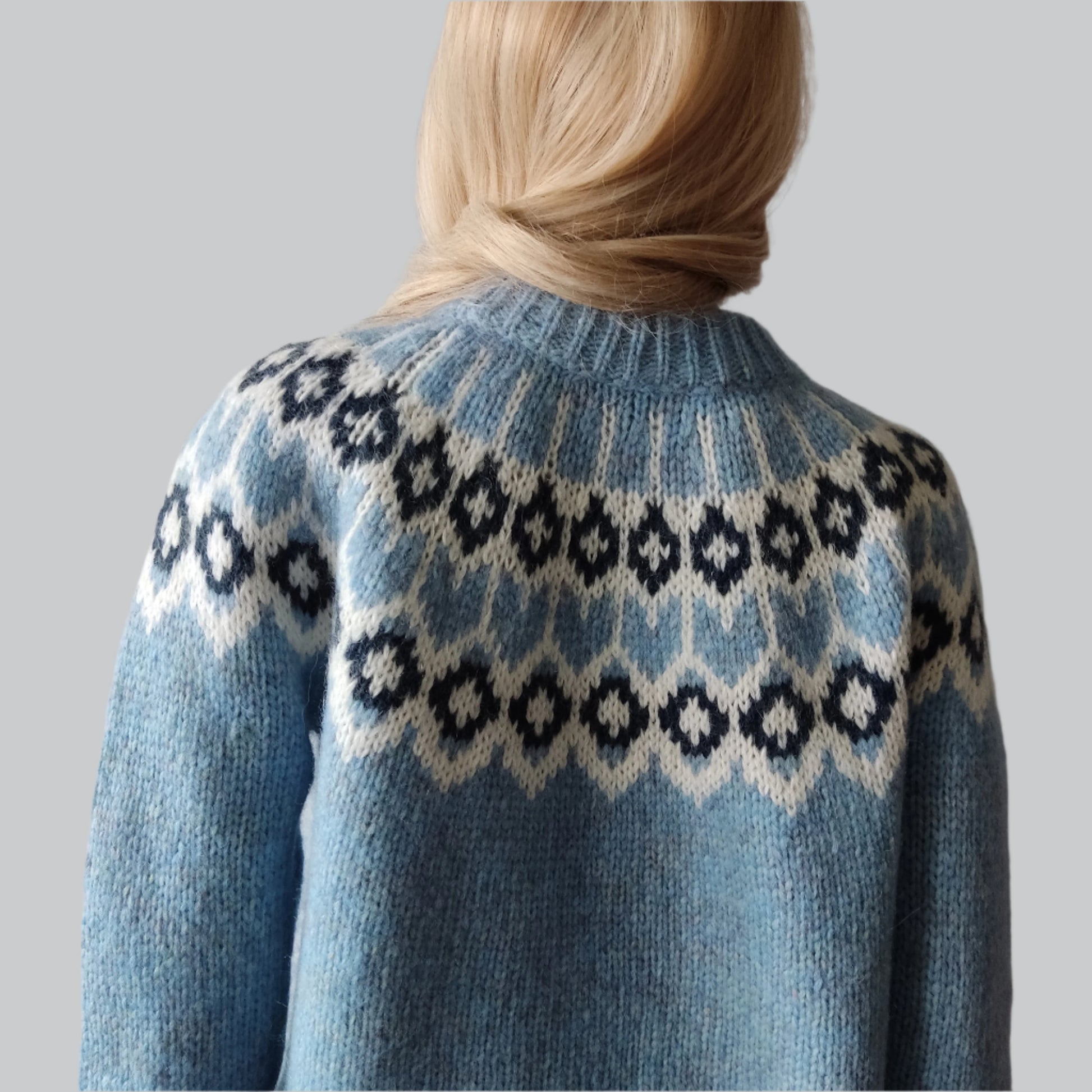 Hand-knitted light blue melange oversized unisex chunky knit Scandinavian sweater Lopapeysa Fair Isle with a white and navy Nordic round yoke, featuring a double collar, ribbed hem, and cuffs in light blue, made from soft hypoallergenic baby alpaca and extrafine merino wool.