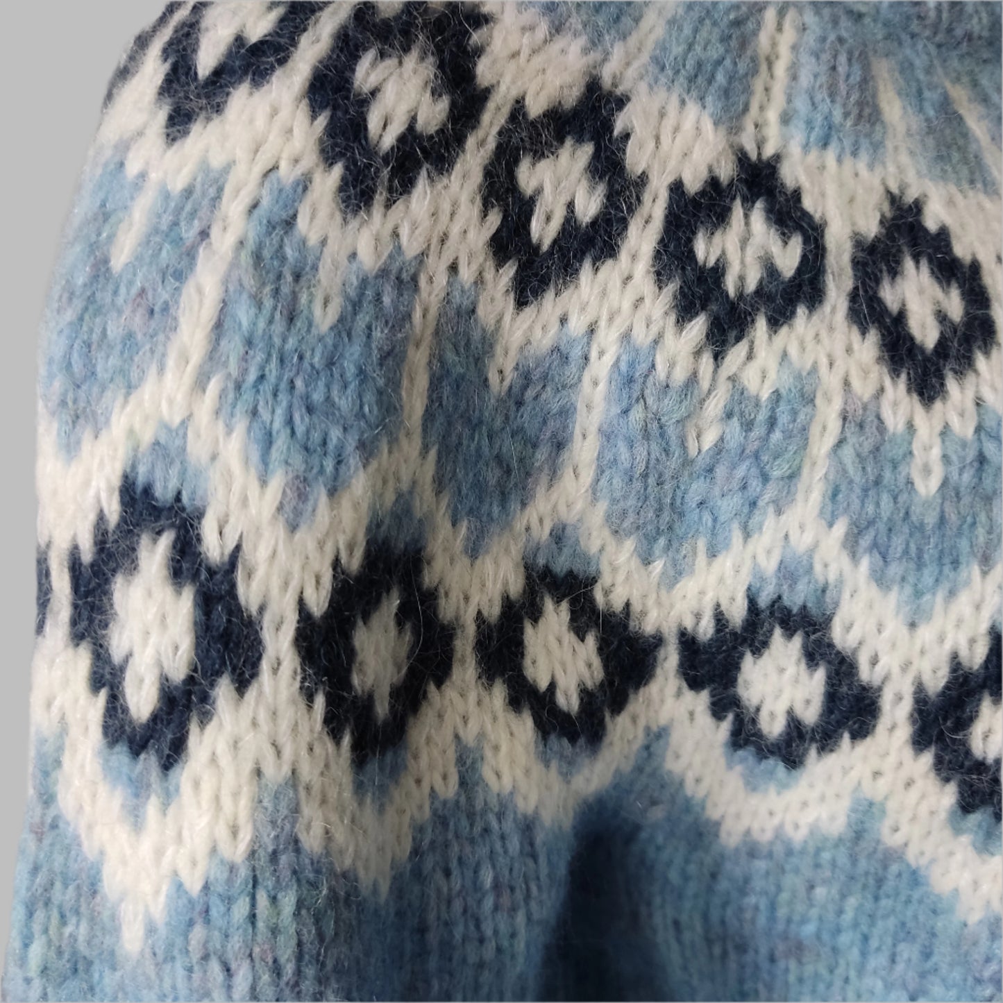 Hand-knitted light blue melange oversized unisex chunky knit Scandinavian sweater Lopapeysa Fair Isle with a white and navy Nordic round yoke, featuring a double collar, ribbed hem, and cuffs in light blue, made from soft hypoallergenic baby alpaca and extrafine merino wool.