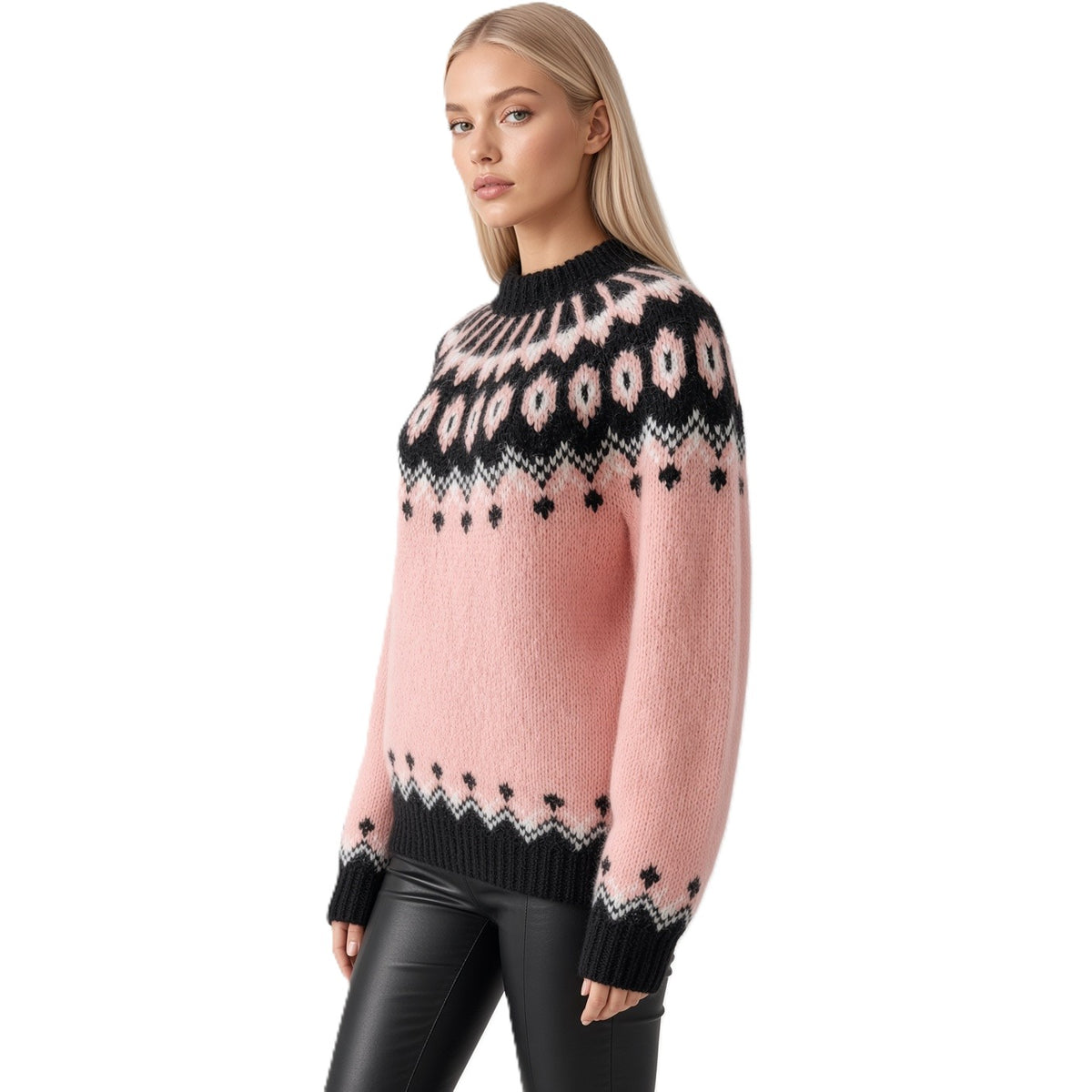 A blonde model wearing a pink knit sweater with a black and white Fair Isle pattern across the yoke and cuffs, paired with black leather pants, against a solid white background.