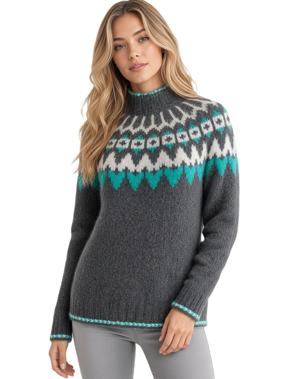 A woman modeling a dark gray knit sweater with a white and teal Fair Isle pattern across the chest and collar, paired with gray pants against a white background.