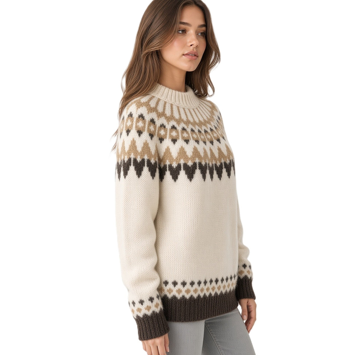 A woman wearing a cream-colored knit sweater with a brown and beige Fair Isle pattern across the chest and cuffs, paired with light gray jeans, against a plain white background.