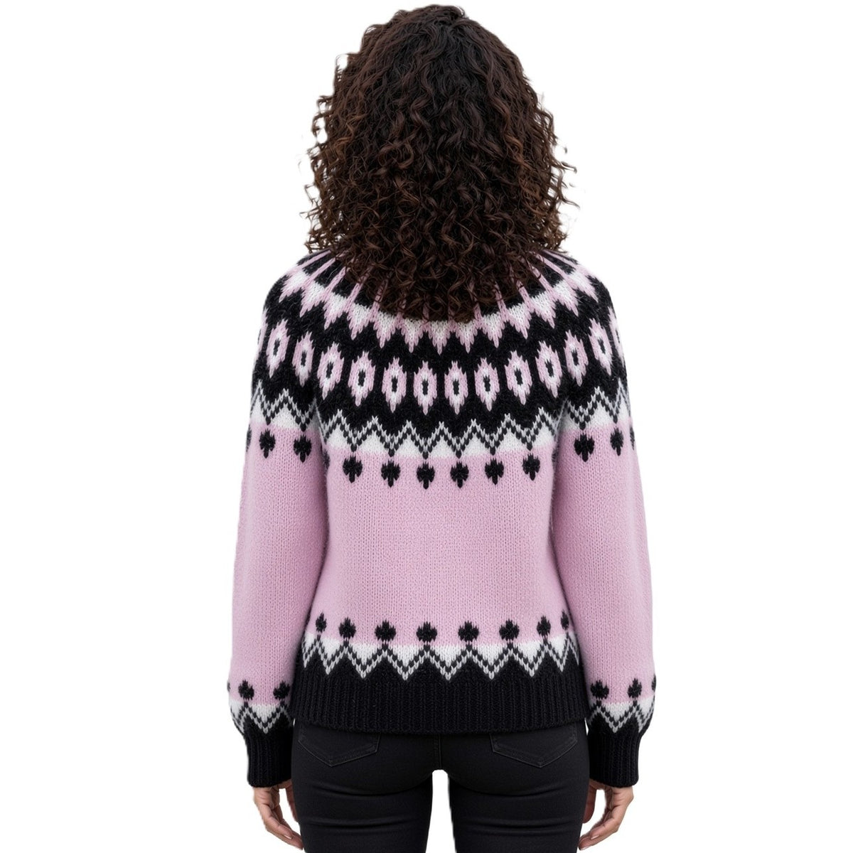 A woman viewed from behind wearing a pink knit sweater with a black and white Fair Isle pattern across the shoulders, back, and cuffs, paired with black pants against a white background.