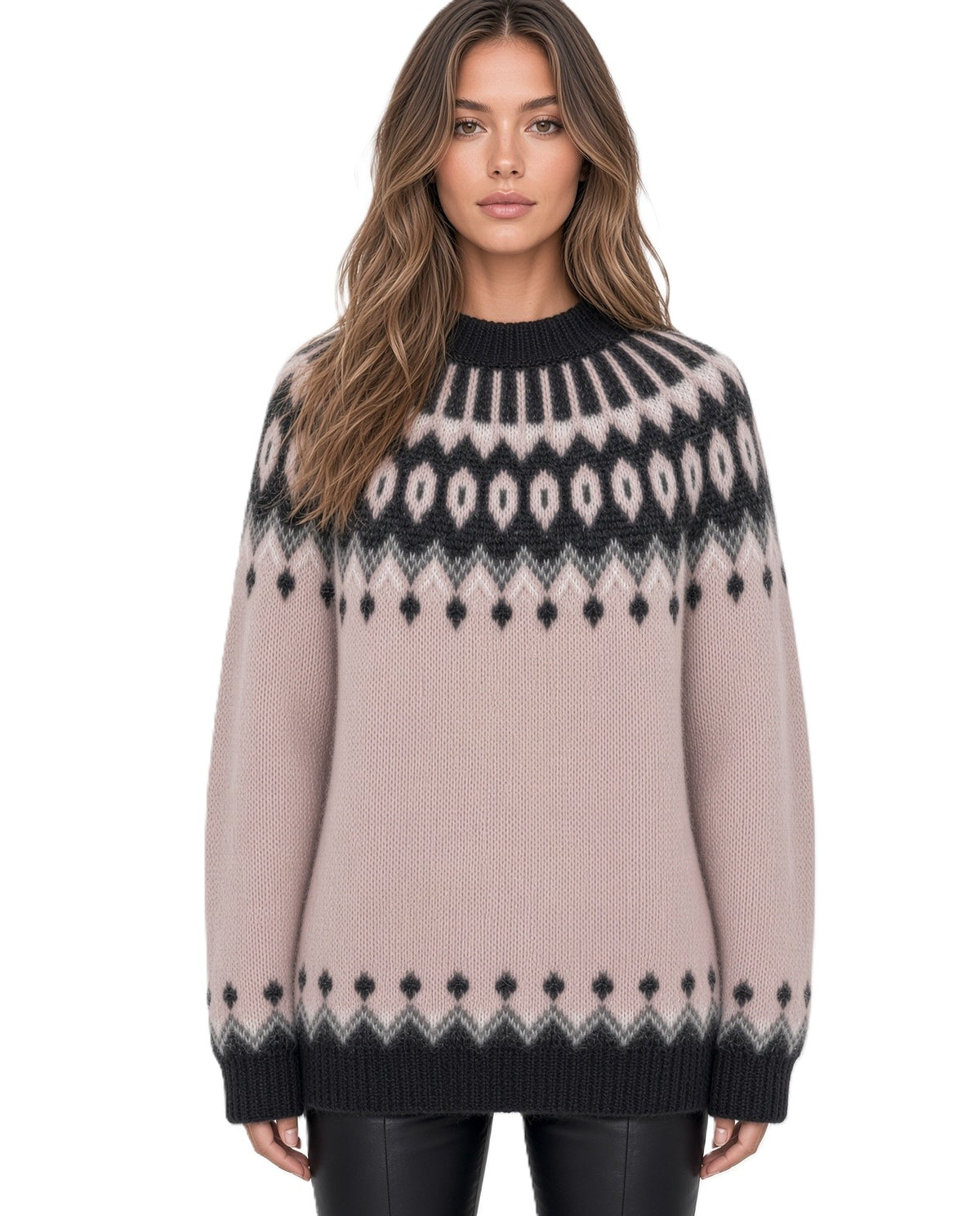 A woman wearing a light pink Fair Isle knit sweater with black and white geometric patterns, paired with black leather pants, against a plain white background.