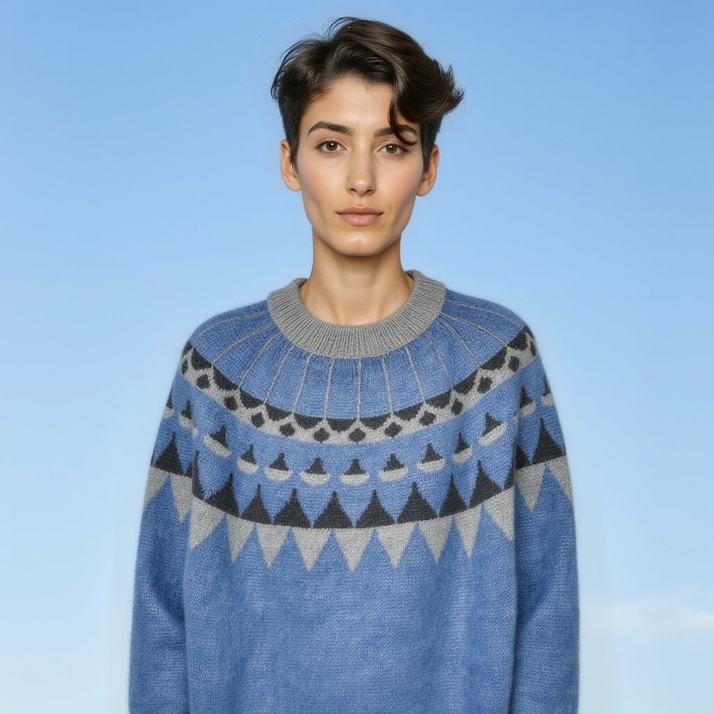 Person wearing a blue and gray patterned sweater against a light blue background