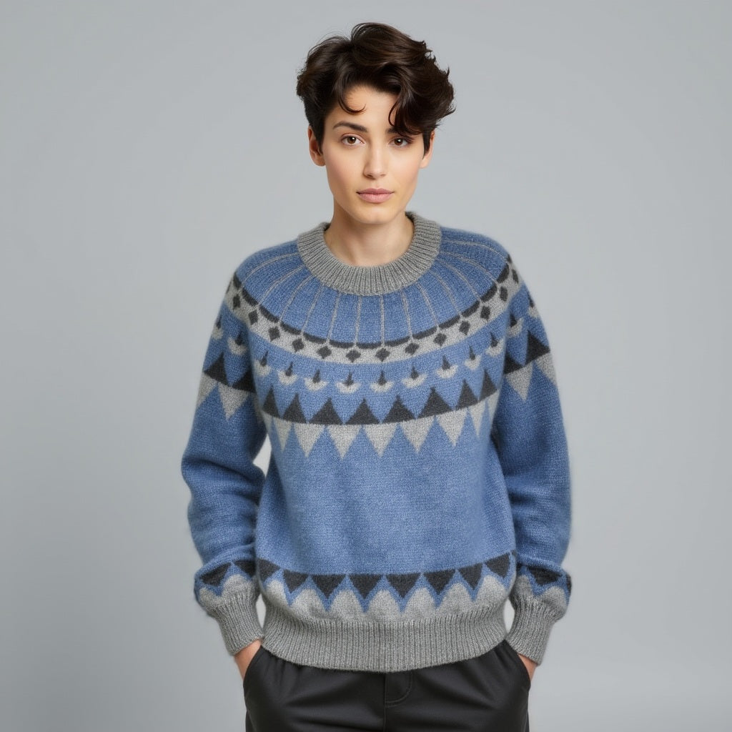 Person wearing a blue and gray patterned sweater on a gray background