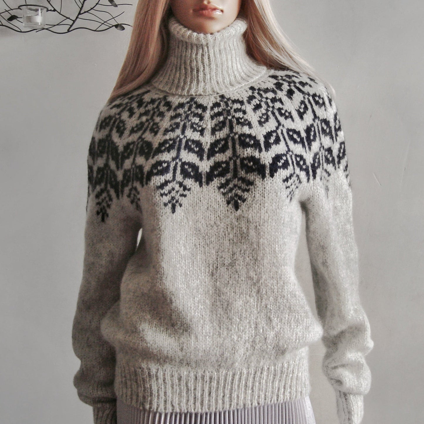 Person wearing a patterned sweater with a plain background