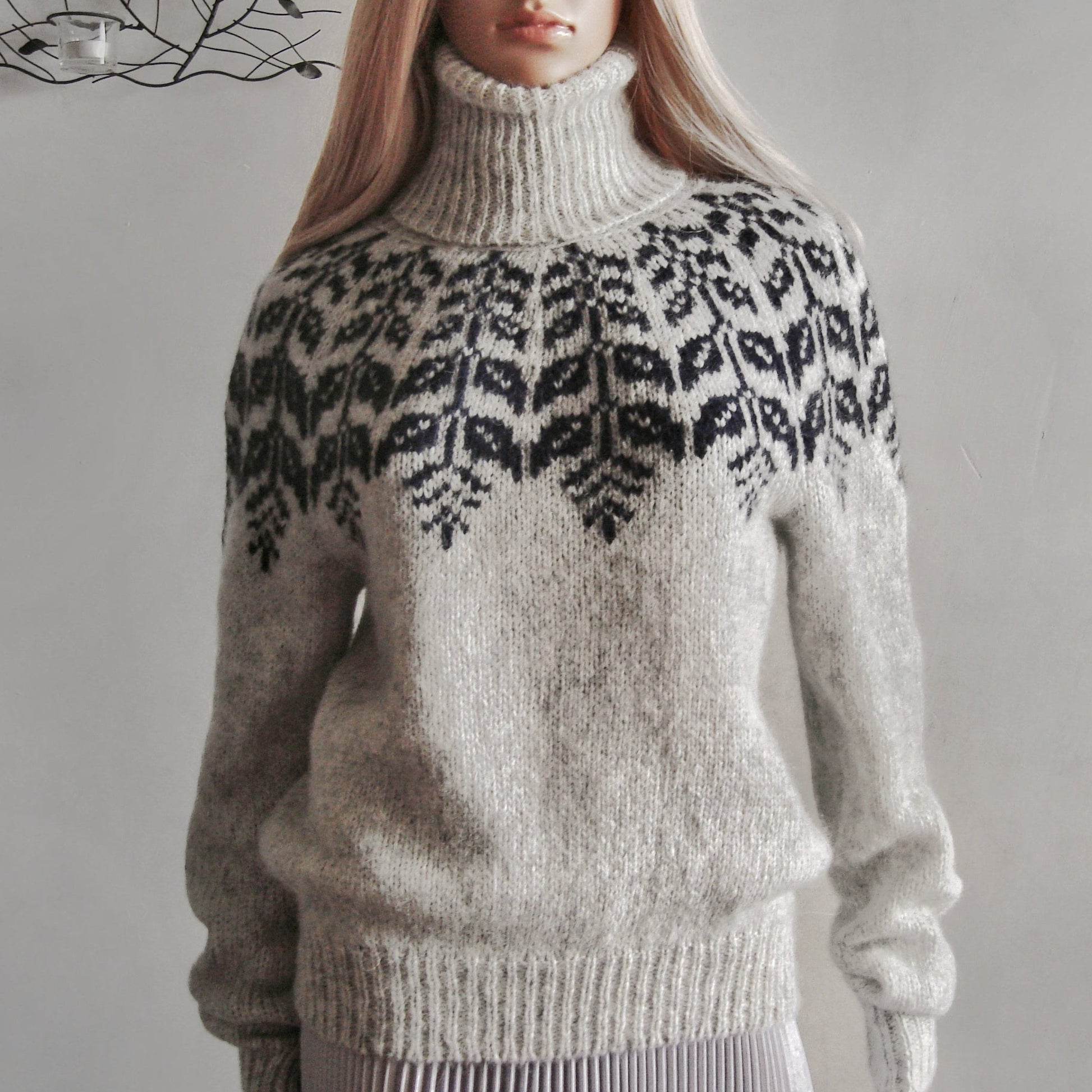 Person wearing a patterned sweater with a plain background