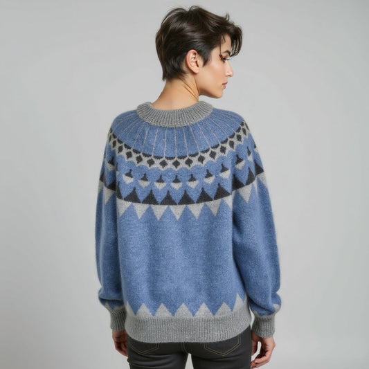 Person wearing a blue and gray patterned sweater on a plain background